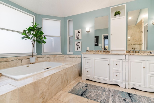 bathroom featuring double vanity, a garden tub, a sink, and tiled shower