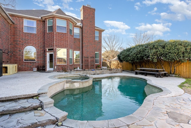 view of swimming pool featuring a pool with connected hot tub, a fenced backyard, and a patio