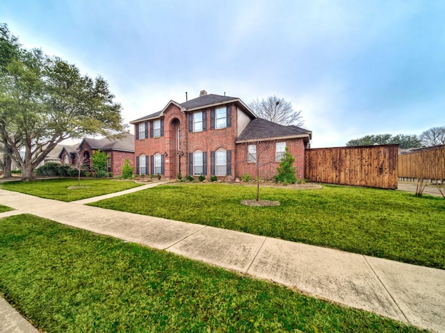 view of front of property with brick siding, fence, a chimney, and a front lawn