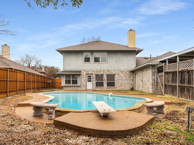 view of pool featuring a fenced in pool, a fenced backyard, and a diving board