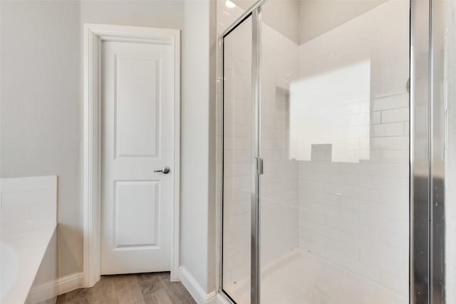 bathroom with shower with separate bathtub and hardwood / wood-style floors