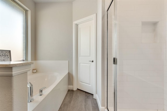 bathroom featuring separate shower and tub and hardwood / wood-style floors