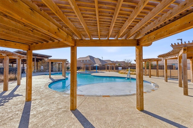 community pool with a patio area, fence, a residential view, and a pergola