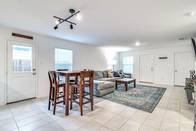 living room featuring light tile patterned floors, baseboards, and visible vents