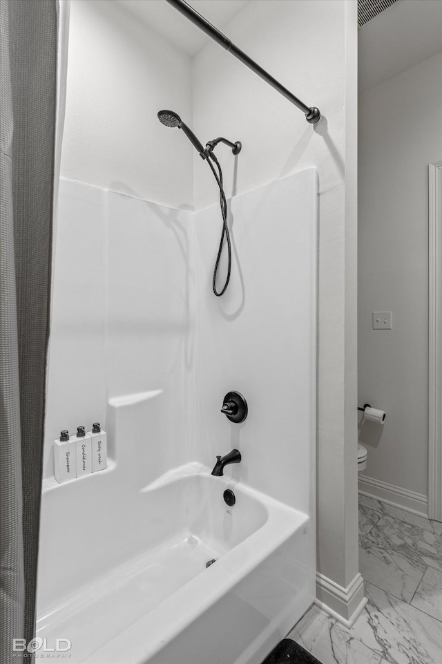 bathroom featuring bathing tub / shower combination and toilet