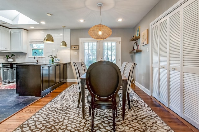 dining area featuring dark hardwood / wood-style flooring, a skylight, and sink