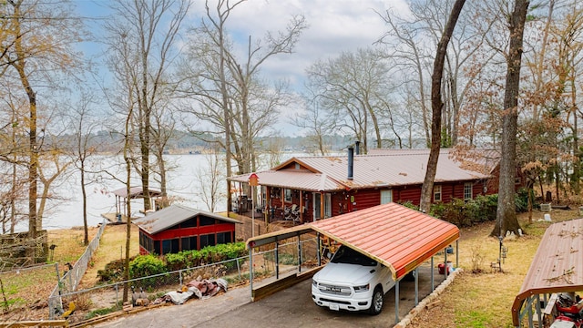 exterior space featuring a sunroom, a water view, and a carport