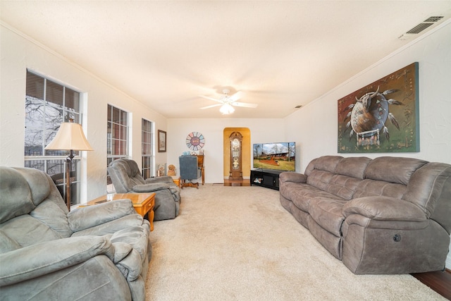 living room featuring ceiling fan, carpet flooring, and crown molding