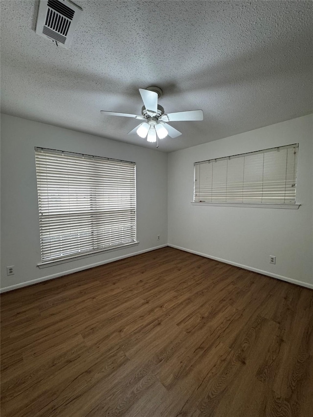 unfurnished room featuring a textured ceiling, ceiling fan, and dark hardwood / wood-style floors