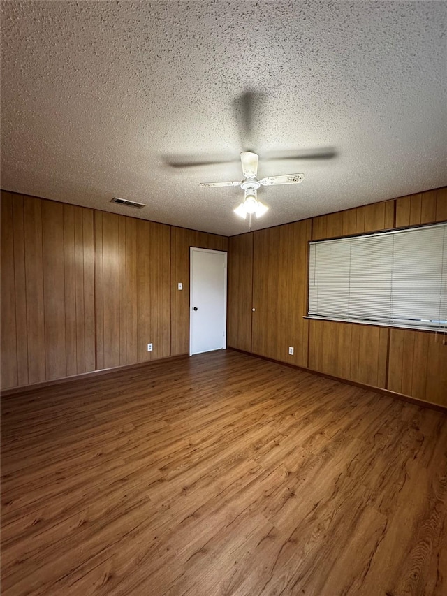 spare room featuring a textured ceiling, ceiling fan, and light hardwood / wood-style floors