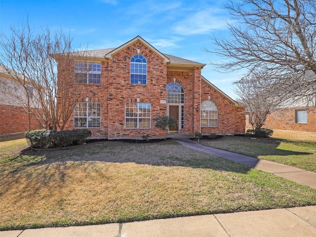 view of front of property featuring brick siding and a front lawn