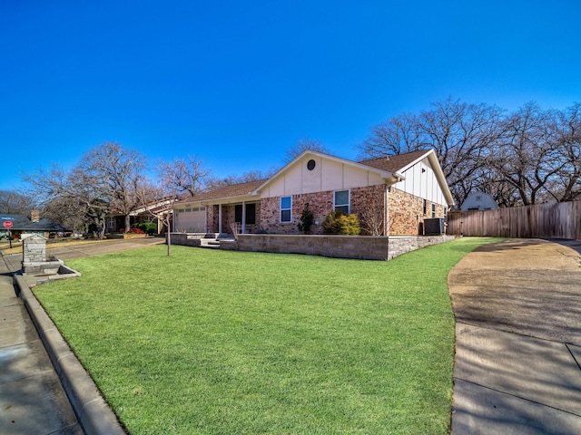 view of front of home featuring a garage, central air condition unit, and a front lawn