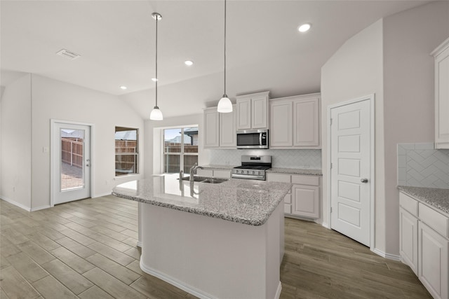 kitchen featuring white cabinetry, wood finished floors, appliances with stainless steel finishes, and a sink