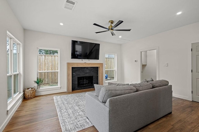 living area featuring a fireplace, wood finished floors, visible vents, and recessed lighting