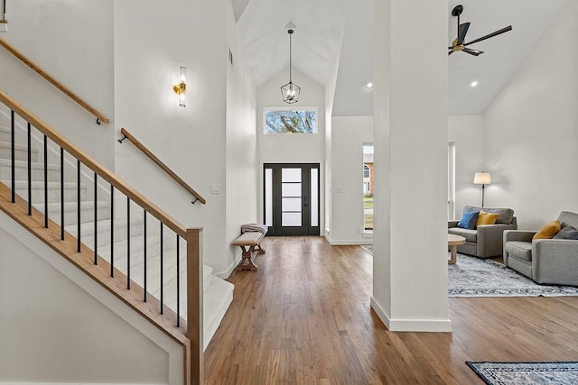 foyer featuring visible vents, stairs, high vaulted ceiling, and wood finished floors