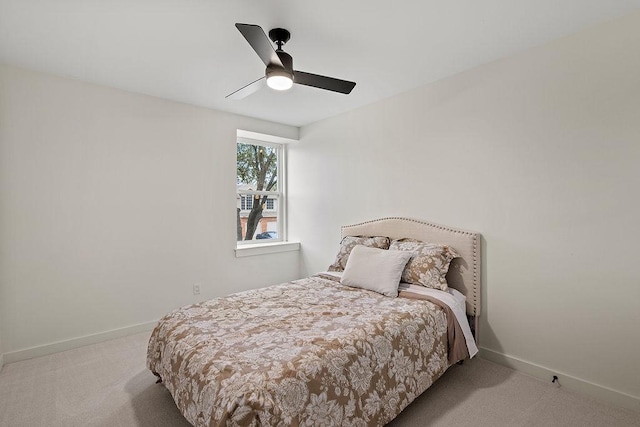 bedroom with light carpet, ceiling fan, and baseboards