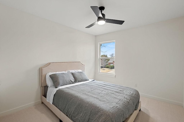 bedroom featuring a ceiling fan, light colored carpet, and baseboards