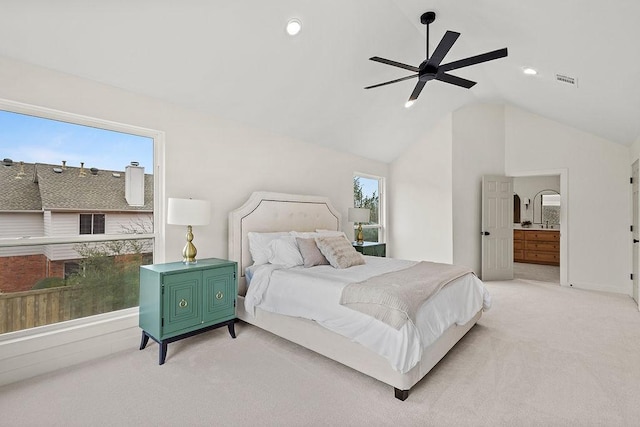 bedroom featuring lofted ceiling, light colored carpet, visible vents, a ceiling fan, and connected bathroom