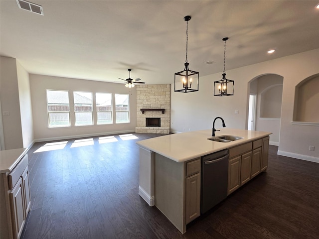 kitchen with a sink, dishwasher, ceiling fan, a fireplace, and visible vents