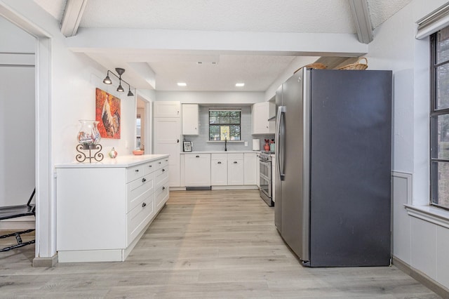 kitchen with white cabinetry, appliances with stainless steel finishes, light countertops, and beam ceiling