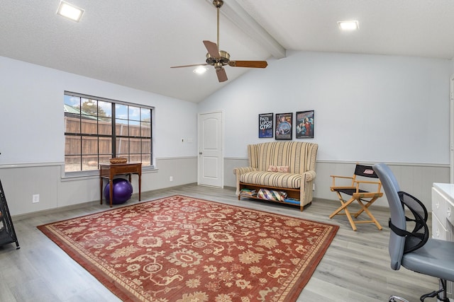 office featuring vaulted ceiling with beams, a wainscoted wall, light wood-style flooring, and a textured ceiling