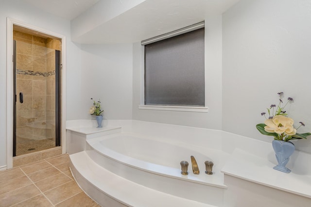 bathroom with tile patterned flooring, a shower stall, and a bath