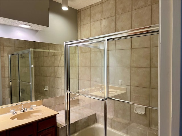 bathroom featuring tiled shower / bath, a textured ceiling, and vanity