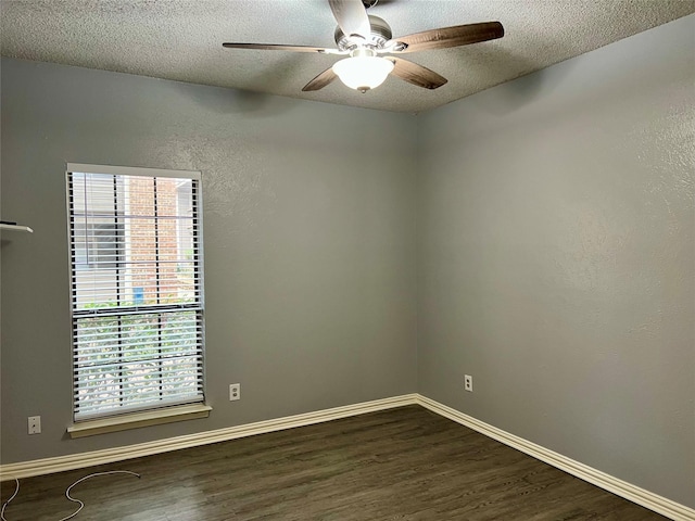 unfurnished room with a textured ceiling, dark wood-type flooring, and baseboards