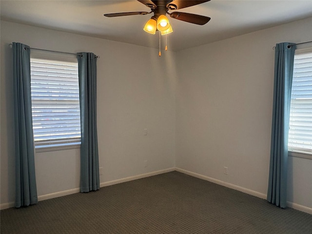 spare room with dark carpet and ceiling fan