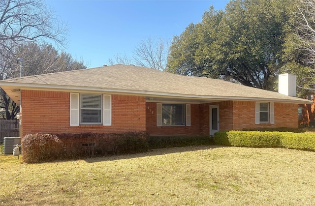 view of front of property with a chimney, a front lawn, cooling unit, and brick siding