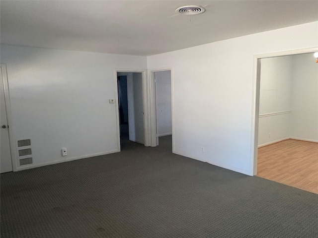 empty room with dark colored carpet