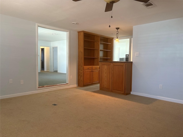 interior space featuring light carpet and ceiling fan