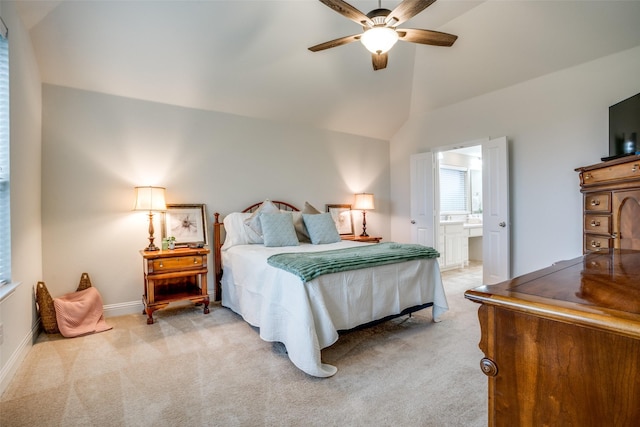 bedroom with lofted ceiling, a ceiling fan, light carpet, ensuite bath, and baseboards