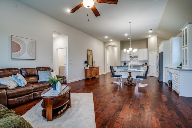 living area with arched walkways, ceiling fan, baseboards, vaulted ceiling, and dark wood finished floors