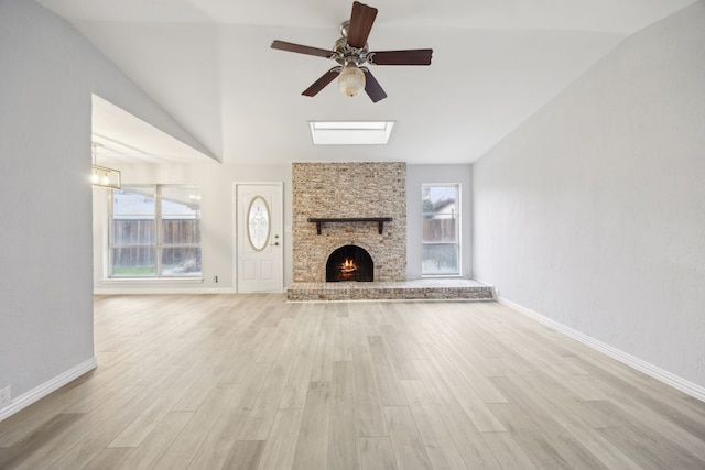 unfurnished living room featuring a fireplace, vaulted ceiling, light wood-style flooring, and baseboards