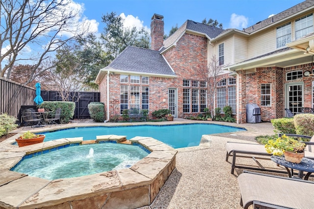 view of pool with a patio, an in ground hot tub, and grilling area