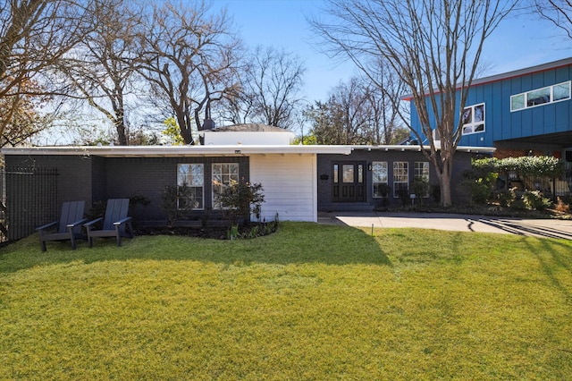 rear view of property featuring brick siding and a yard