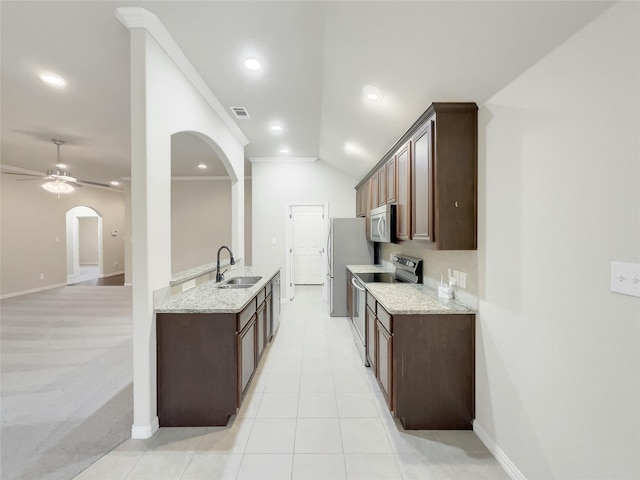 kitchen featuring sink, ceiling fan, stainless steel appliances, and light stone counters