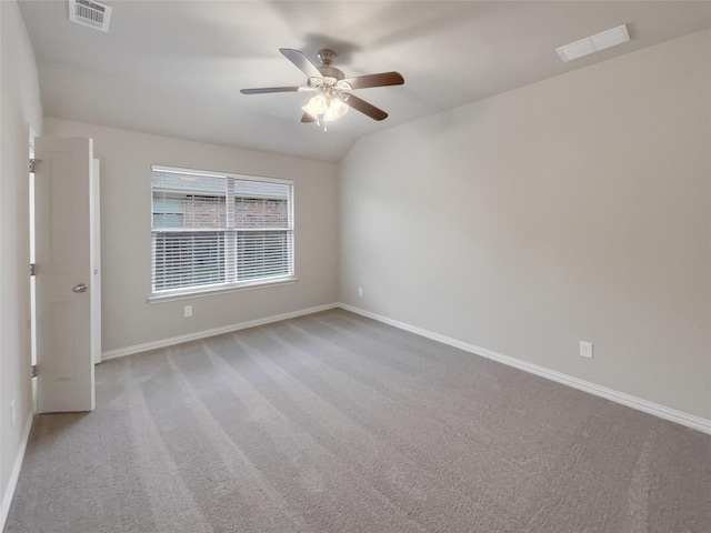 carpeted spare room featuring vaulted ceiling and ceiling fan