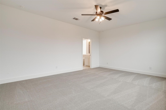 empty room featuring ceiling fan and light colored carpet