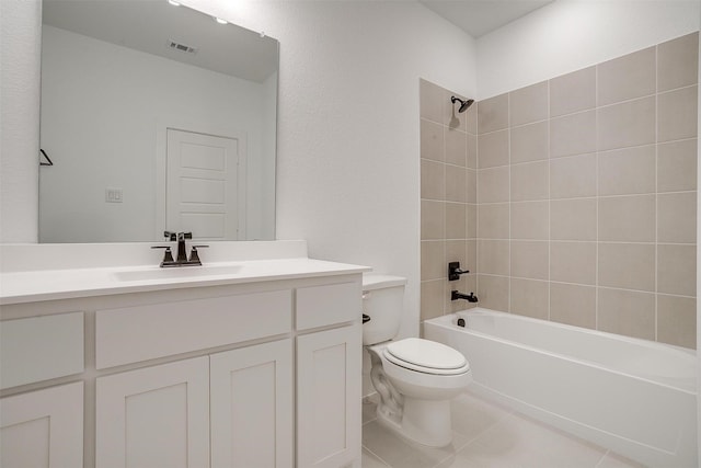 full bathroom featuring tile patterned floors, toilet, vanity, and tiled shower / bath combo