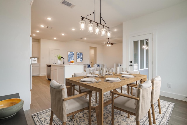 dining room featuring sink, ceiling fan, and wood-type flooring