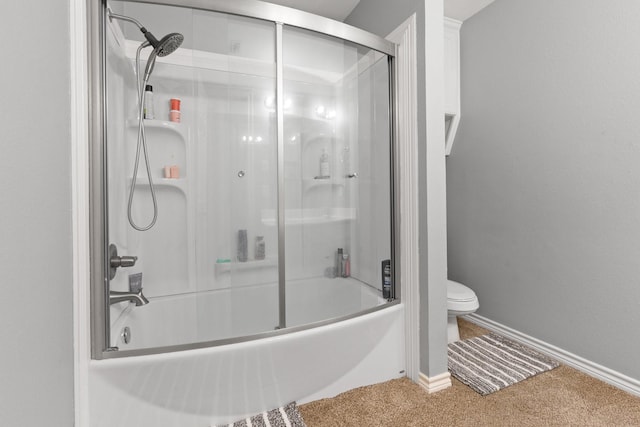 bathroom featuring toilet and combined bath / shower with glass door