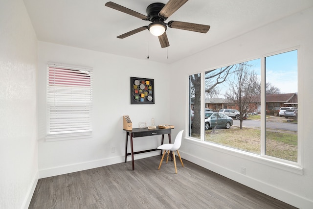 office area with a ceiling fan, baseboards, and wood finished floors