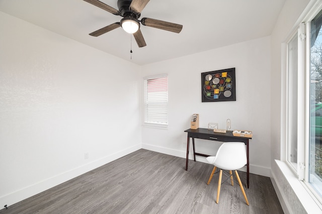 office area featuring a ceiling fan, a wealth of natural light, baseboards, and wood finished floors