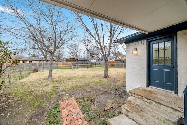 view of yard featuring entry steps and a fenced backyard