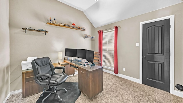 office space with baseboards, vaulted ceiling, and light colored carpet