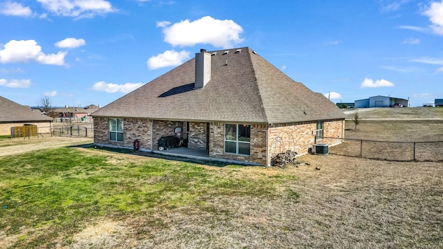 rear view of property with central AC unit, brick siding, fence, a yard, and a patio area