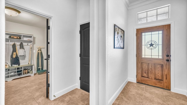 foyer featuring ornamental molding, baseboards, and light tile patterned floors