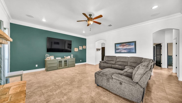 living area featuring arched walkways, crown molding, visible vents, ceiling fan, and baseboards